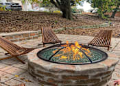 Thumbnail 11 of 20 - a fire pit with two wooden chairs around it